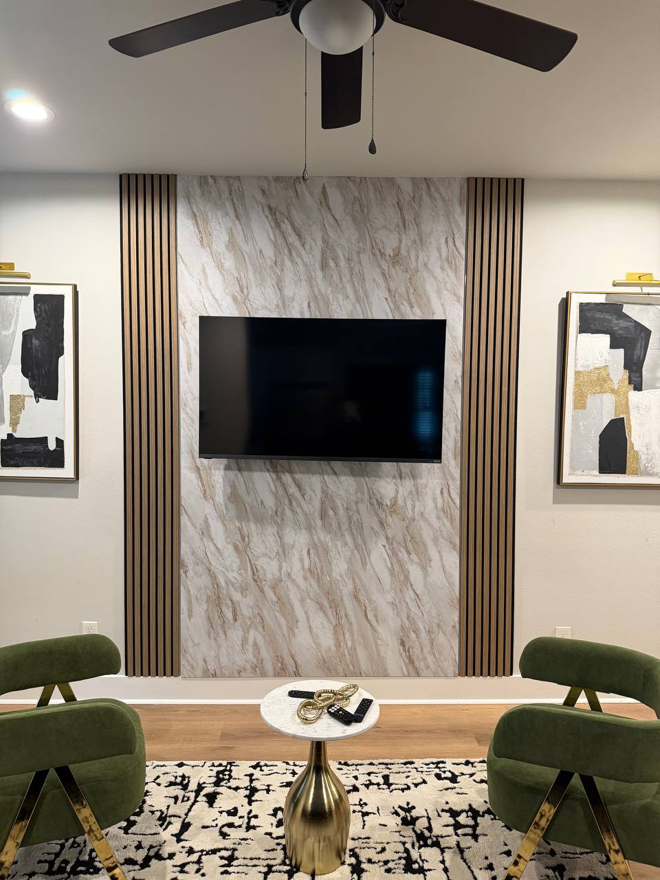 Luxury Marble Accent Wall TV Mounting Houston | Carlos TV Mounting Luxury marble accent wall TV mounting with green chairs and premium finished room in Houston