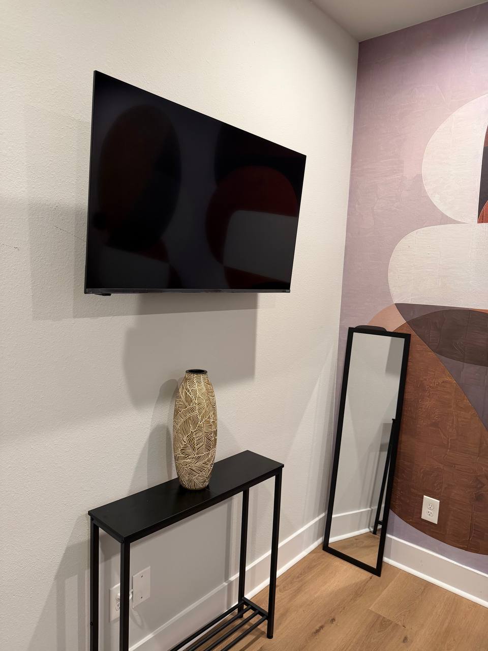 Luxury corner TV mounting with clean wall placement and modern room styling in Houston