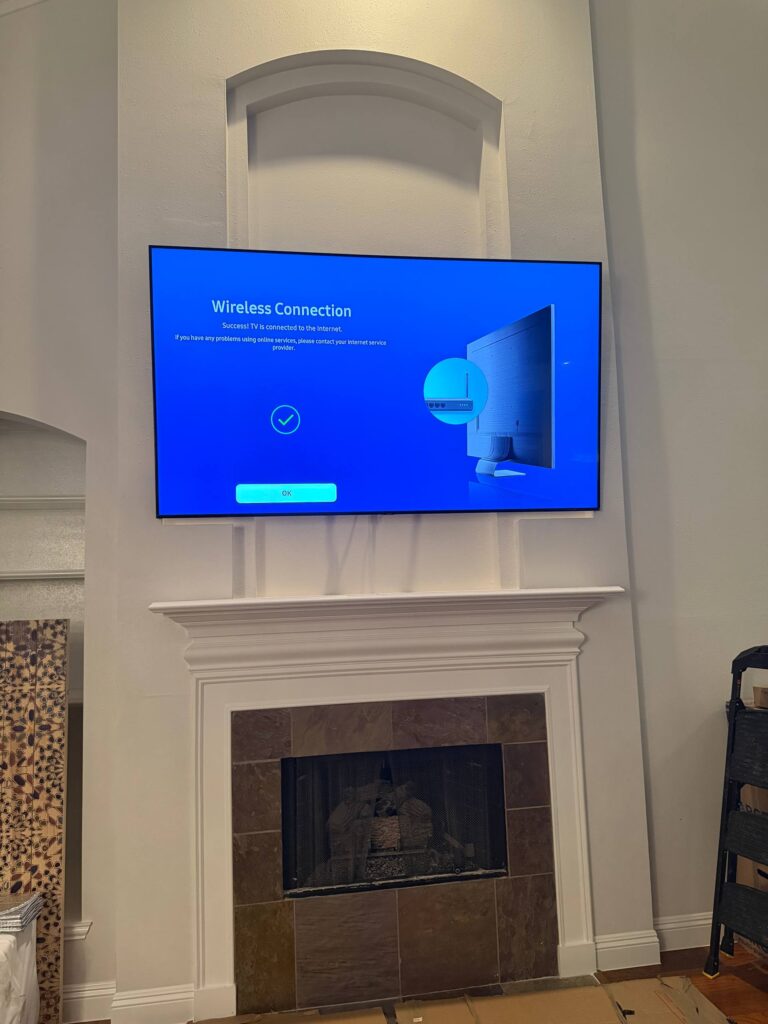 Finished fireplace TV mounting setup with a clean centered installation in Houston