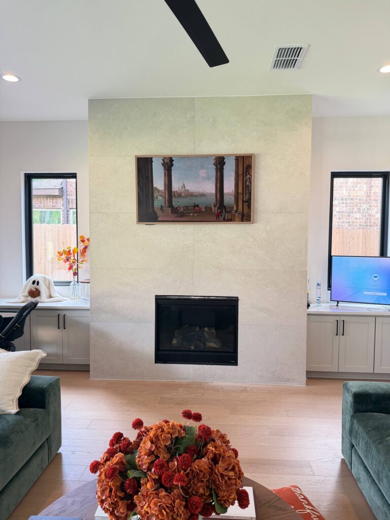 Luxury Frame TV above a tiled fireplace with concealed wires in a Houston home