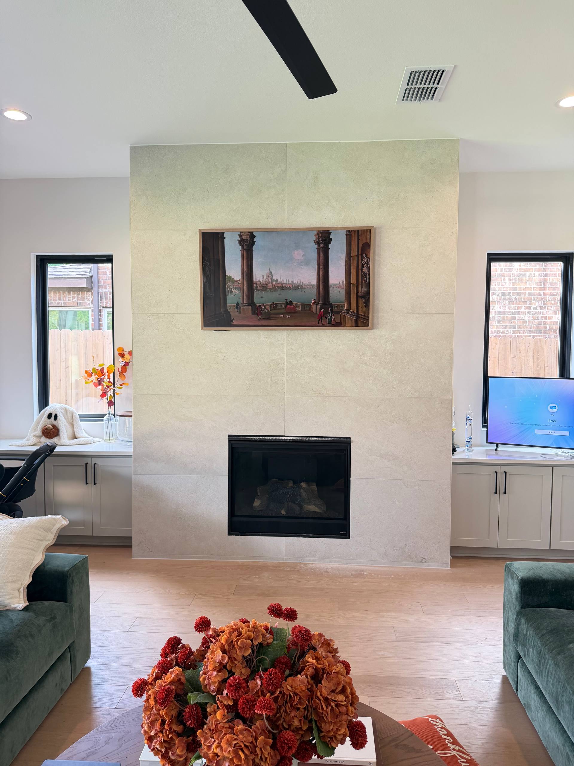 Flush Frame TV above a tiled fireplace with concealed wiring in a Houston home
