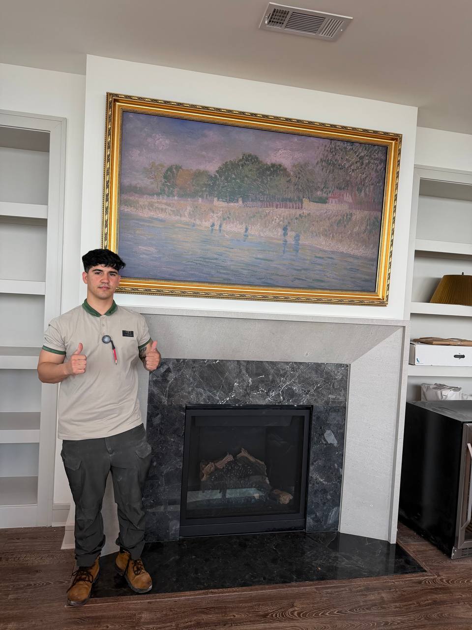 Carlos TV Mounting installer beside a completed TV installation above a fireplace in Houston